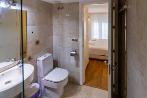 a bathroom with a toilet and a sink and a bed at SH Brisa de la Viña Cerca de la Playa AC, WIFi in Cádiz