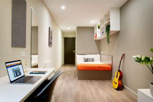 a bedroom with a desk and a bed with a laptop at For Students Only - Saw Mill in Huddersfield in Huddersfield