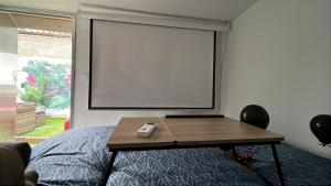 a projection screen in a room with a table at Les Studios Parfaitement Imparfaits - Lens Louvre-Bollaert in Lens