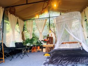 a bedroom with a canopy bed in a tent at Mây Glamping in Xuân Thọ