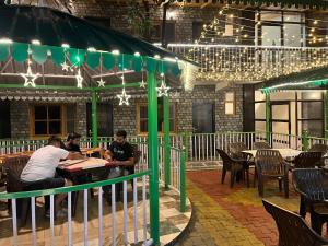 a group of people sitting at a table in a restaurant at Heyan Cedar Woods Nainital in Nainital