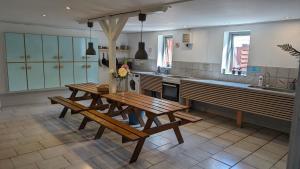 una cocina con 2 bancos de madera y una mesa en Ørsted Outdoor,  4 fotos más