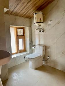 a bathroom with a toilet and a window at The Highgrove House, Manali in Haripūr +79 photos