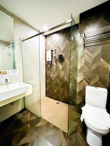 a bathroom with a shower and a toilet and a sink at Kino Hotel in Shah Alam +94 photos