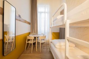 a small room with a bunk bed and a table and chairs at Grand Juste in Marseille