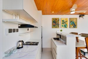 a kitchen with white countertops and a wooden ceiling at Cozy Honeymoon 1BR Villa Cempaka LaLuxe A9 Sanur in Sanur