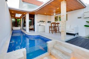 a swimming pool in the middle of a house at Cozy Honeymoon 1BR Villa Cempaka LaLuxe A9 Sanur in Sanur