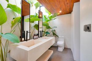a bathroom with a sink and a toilet and plants at Cozy Honeymoon 1BR Villa Cempaka LaLuxe A9 Sanur in Sanur +18 photos