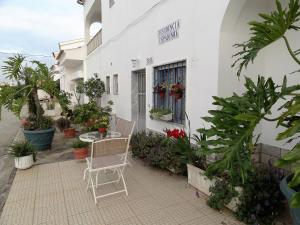 a patio in front of a white building with plants at Residencial Espadinha in Quarteira