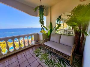 a balcony with a couch and a view of the ocean at Panoramic Cala Canyelles, Pool in Roses