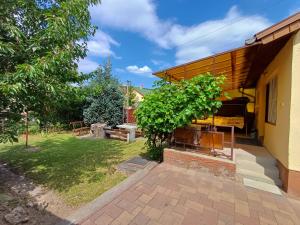 ボガーチにあるDenFi Vendégházの庭にグリル付きのパティオがある家