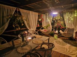 a dining room with a table and chairs and flowers at Maizītes krasts in Skrīveri +12 photos