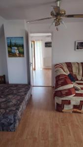 a bedroom with a bed and a couch and a fan at Norbi Vendégház in Balatonszárszó