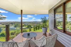 einen Balkon mit Stühlen, einem Tisch und Aussicht in der Unterkunft Cape Vue - Vue 5 Byron Bay in Ewingsdale