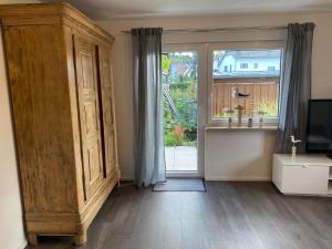 a room with a large wooden cabinet and a window at Ferienwohnung Bianca in Ettenheim