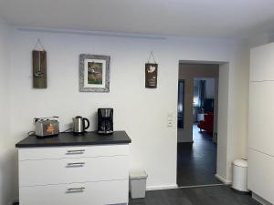 a kitchen with white cabinets and a black counter top at Ferienwohnung Bianca in Ettenheim