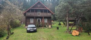 a car parked in front of a log house at Яглина in Sprynya +7 photos
