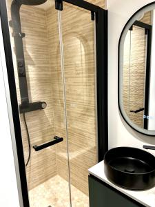a bathroom with a shower with a sink and a mirror at LILLEHOSTS 2, Vieux Lille, Newly renovated, Modern & Stylish apartment, perfectly located in Lille