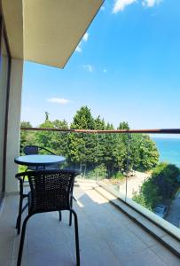 ヴァルナ・シティにあるCabacum Pleasure Beachfront Apartmentsの海が見えるバルコニーにテーブルと椅子がある