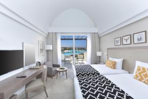 考拉亚湾Steigenberger Resort Alaya Marsa Alam - Red Sea - Adults Friendly 16 Years Plus的一间带床、书桌的酒店房间和一间 更多37张照片
