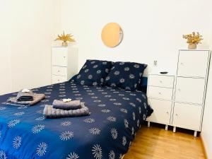 Un dormitorio con una cama con una manta azul. en La Cabane, terrasse, vue dégagée & mer a l'horizon, en Ploemeur