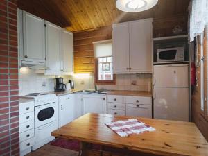 a kitchen with white appliances and a wooden table at Kulkuri in Syöte