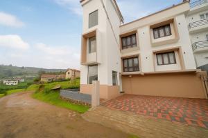 a large white house with a driveway at Away From Home - 8 - HomeStay, Entire 2 BHK Villa in Ooty