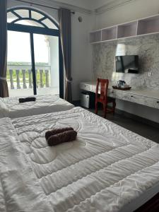 a bedroom with two beds and a desk with a chair at Ranisa Kampot in Kampot