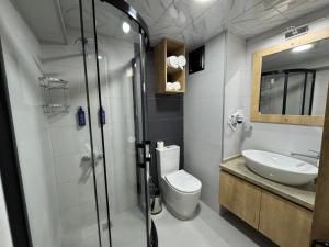 a bathroom with a shower and a toilet and a sink at Alican 1 Hotel in Izmir
