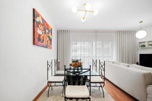 a living room with a table and chairs and a couch at Refúgio do Garajau by Atlântica in Caniço +13 photos