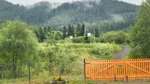 a wooden fence in a field with a mountain at Family House Volosianka in Volosyanka