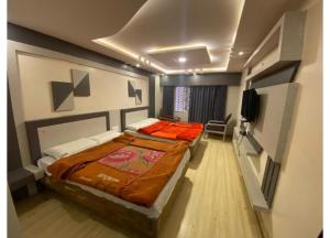 a bedroom with a bed and a flat screen tv at Hotel Golden City in Ooty