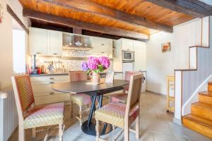 a kitchen with a table and chairs with flowers on it at Les gîtes de Lanevry 800m plage in Kerlaz