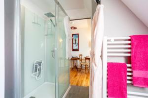 une salle de bains avec douche en verre et une salle à manger dans l'établissement Les gîtes de Lanevry 800m plage, à Kerlaz 110 autres photos