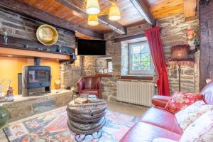 a living room with a couch and a tv at Les gîtes de Lanevry 800m plage in Kerlaz