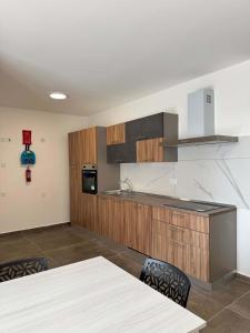 a kitchen with wooden cabinets and a table and chairs at Serenity Escape 2 Bed with Patio in Taʼ Penza