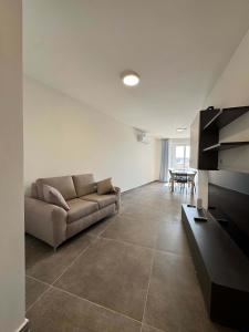 a living room with a couch and a table at Serenity Escape 2 Bed with Patio in Taʼ Penza