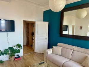 un soggiorno con un divano e uno specchio di Appartement centre historique de Grasse, capitale des parfums a Grasse
