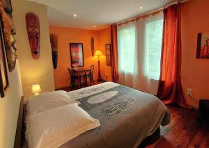 a bedroom with a bed and a table and a window at L'Odyssée VILLA ILOA in Dommartemont