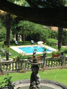 a fountain in a yard with a swimming pool at Villa Angelica in Riva del Garda