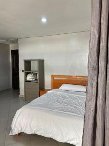 une chambre avec un grand lit avec des draps blancs dans l'établissement Appartement au centre de tanger, à Tanger