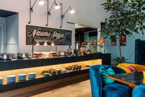 a restaurant with a counter with dishes on it at Naumi Auckland Airport Hotel in Auckland