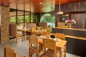 a dining room with wooden tables and chairs at Go Hotels Plus Bacolod - Newly Renovated in Bacolod