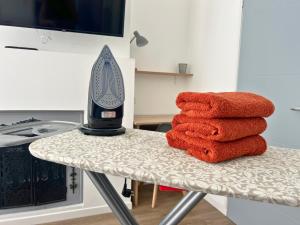 ein Stapel Handtücher mit einem Haartrockner auf einem Tisch in der Unterkunft Le Repaire des 12- Hypercentre, jardin, idéale groupes, 5 chambres 5 salles de bain in Saint-Omer