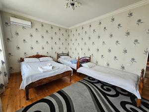 a bedroom with two beds and a rug at Big yard white villa AYT in Gabala