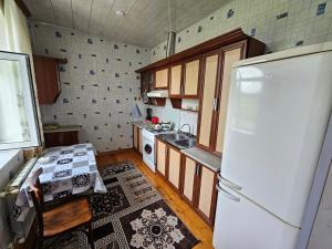 a kitchen with a refrigerator and a table in it at Big yard white villa AYT in Gabala