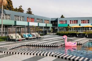 a pink swan in a pool in front of a building at Naumi Auckland Airport Hotel in Auckland