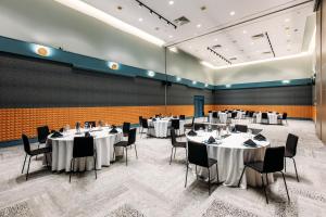 a banquet hall with tables and chairs and a wall at Naumi Auckland Airport Hotel in Auckland
