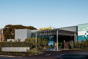 a building with a sign on top of it at Naumi Auckland Airport Hotel in Auckland