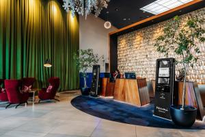 a lobby with a cash register and chairs and a table at Naumi Auckland Airport Hotel in Auckland